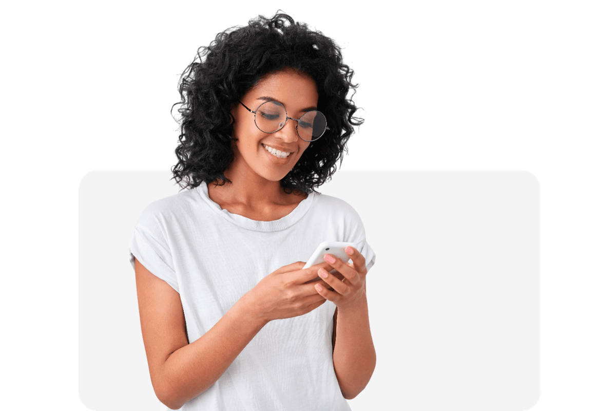 A woman smiling while she uses her smartphone